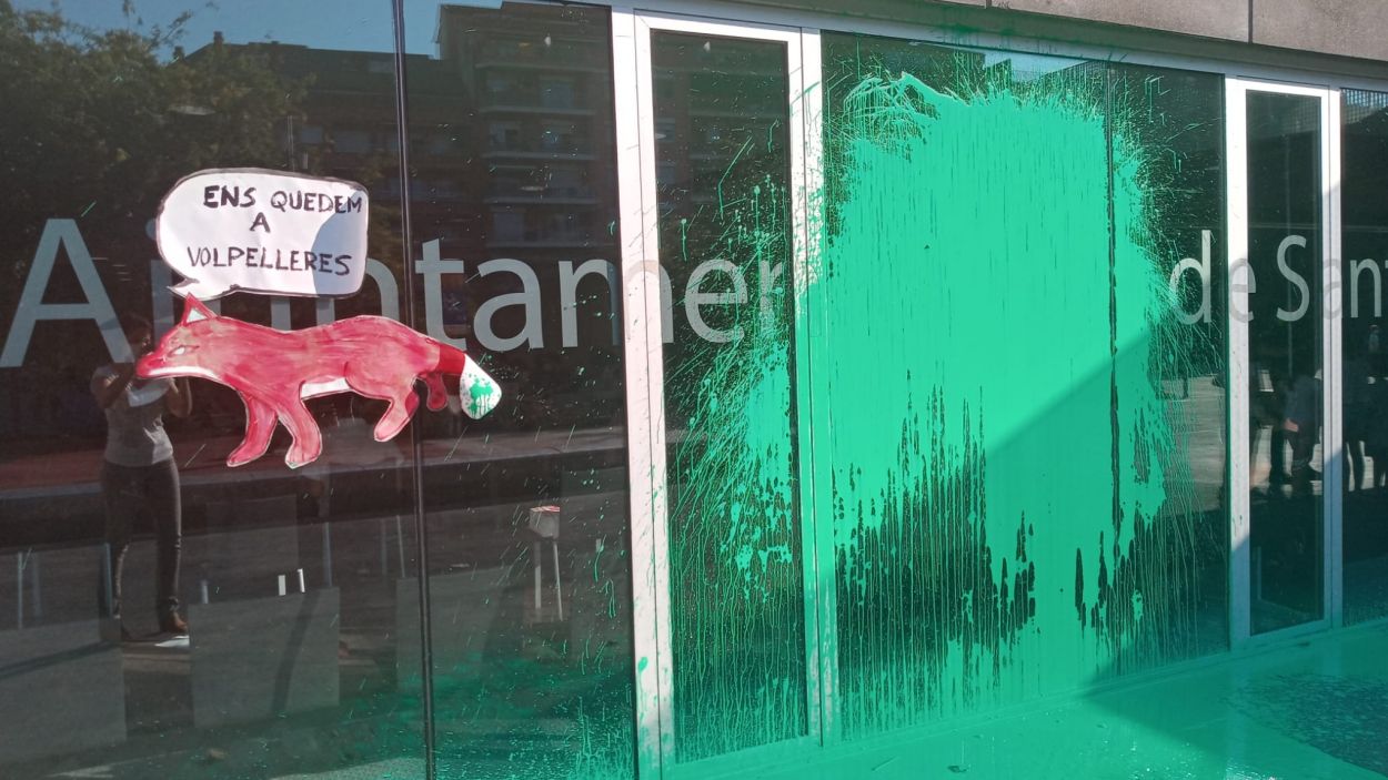 Llancen un pot de pintura verda a la porta de l'ajuntament durant el ple