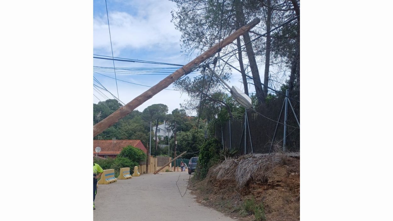 Un camió de les escombraries arrossega el cablejat de tres pals elèctrics a la Floresta