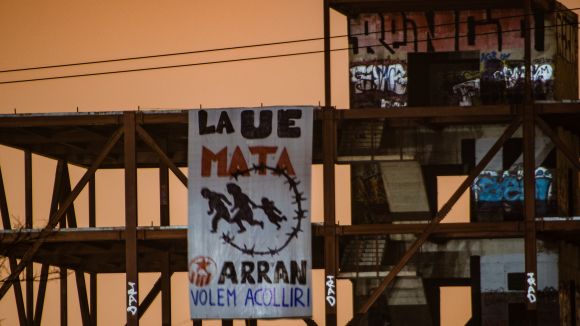 Arran penja una pancarta gegant de suport als refugiats a un edifici a mig construir a Volpelleres