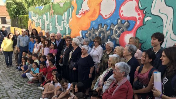 Diverses generacions es troben amb el 'Mural de vida' que llueix la Llar d'Avis de la Parròquia