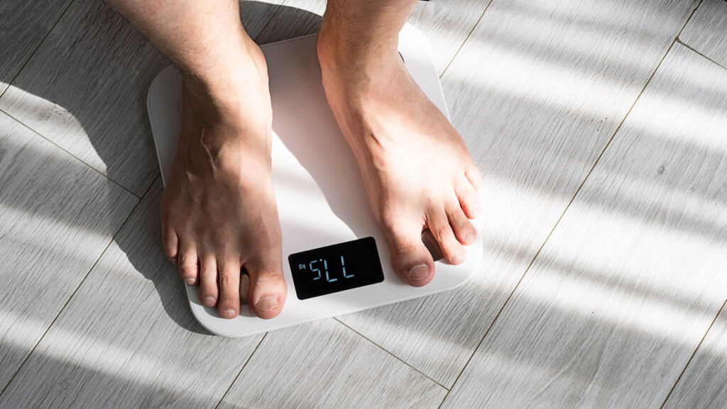 Els peus d'un home sobre una bàscula 