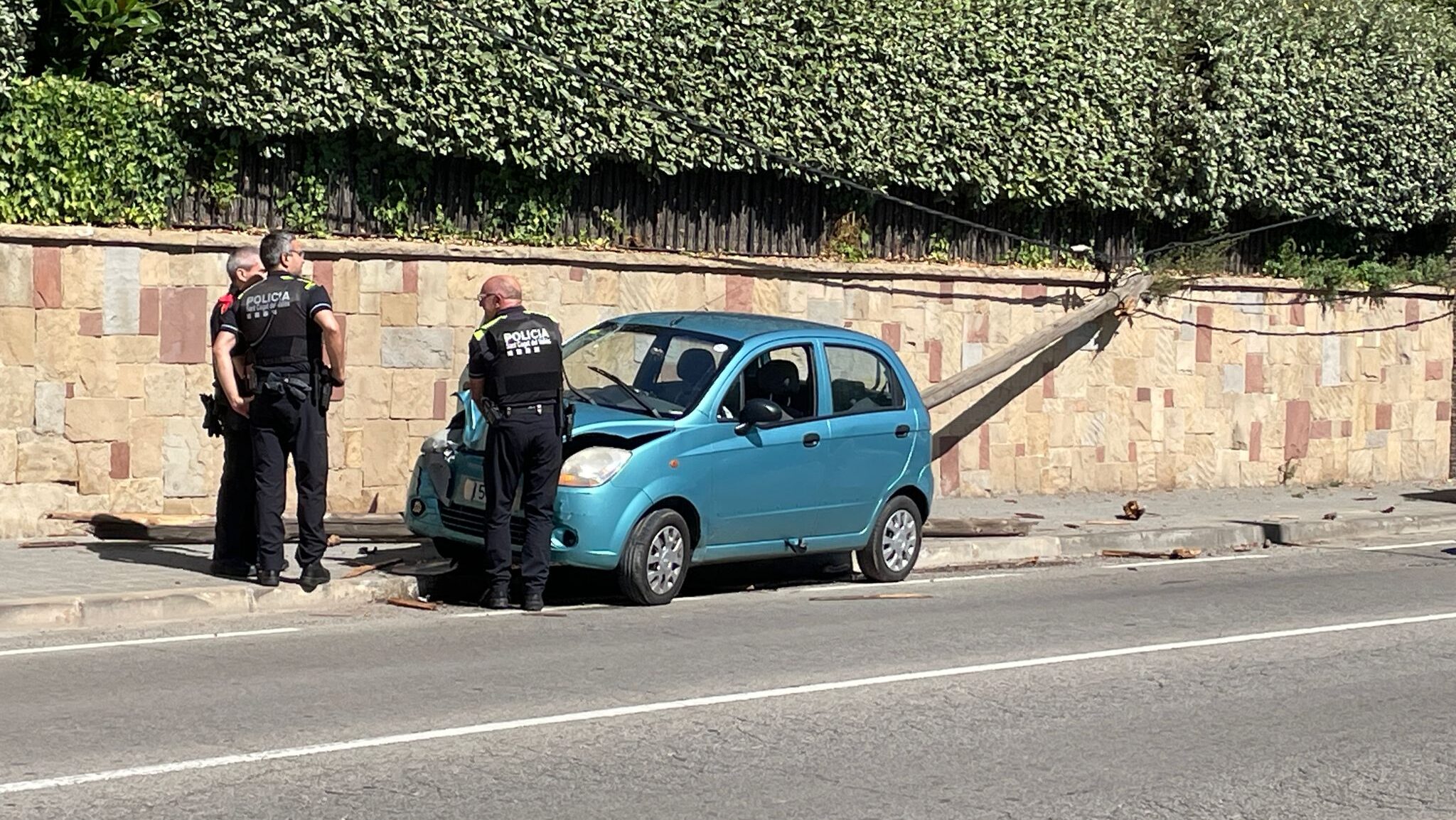 Tres policies del cos dels Mossos d'Esquadra i la Policia Local inspeccionant el lloc de l'accident