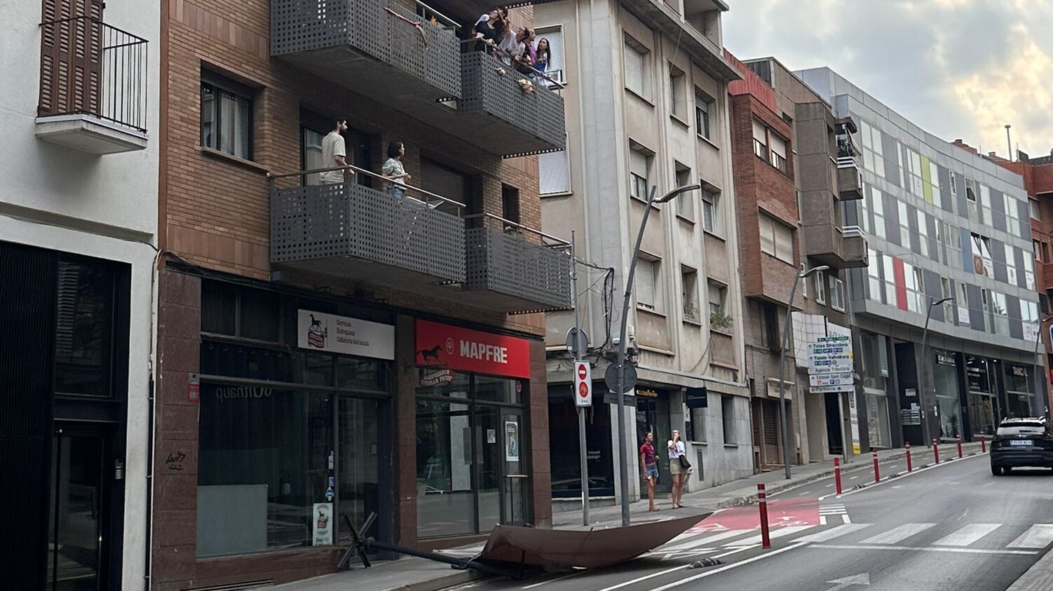 Cau un para-sol al carrer des de dalt d'un edifici del centre de Sant Cugat