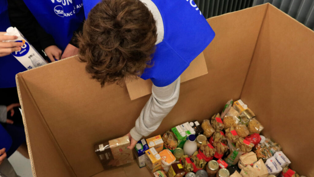 Un voluntari col·loca els aliments recollits